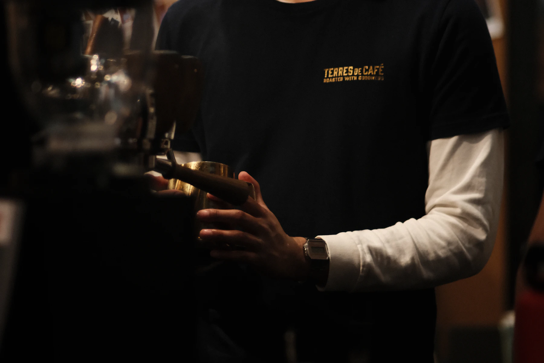 Barista de Lattitude Coffee preparando un café de especialidad con una jarra de latón