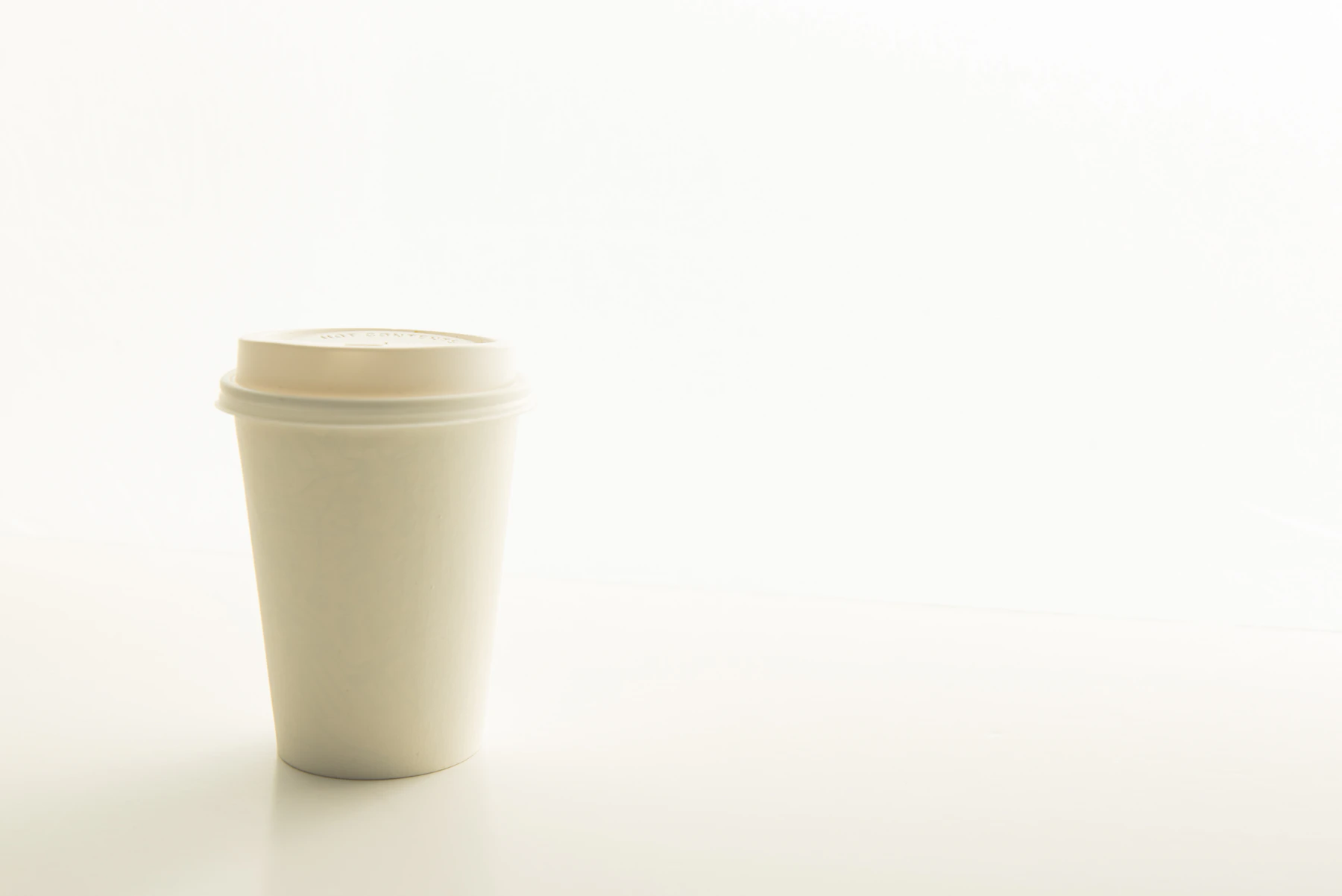 Café de especialidad para llevar en un vaso blanco minimalista
